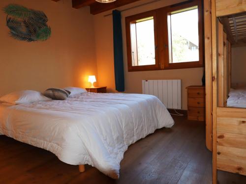 a bedroom with a large white bed and two windows at Chalet Samoëns, 5 pièces, 14 personnes - FR-1-624-7 in Samoëns