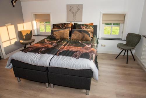 una camera con un grande letto e due sedie di De Donksehoeve a Liempde