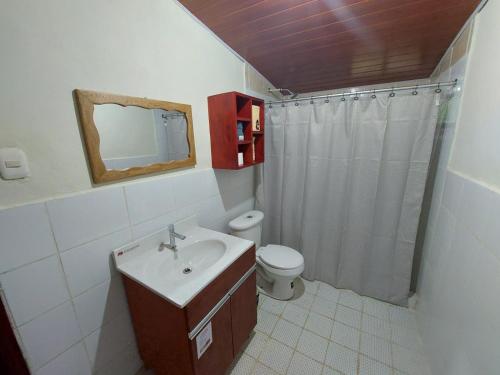 a bathroom with a sink and a toilet and a mirror at Alla Arriba in Las Cruces