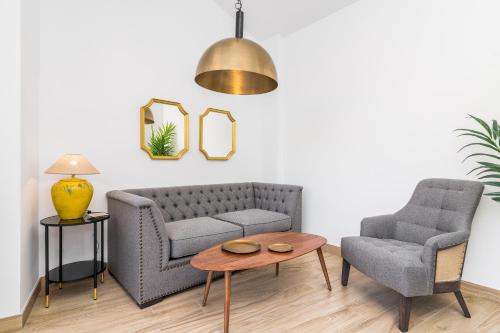 a living room with a couch and a chair and a table at iloftmalaga Santa María in Málaga