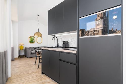 a kitchen with black cabinets and a counter top at iloftmalaga Santa María in Málaga