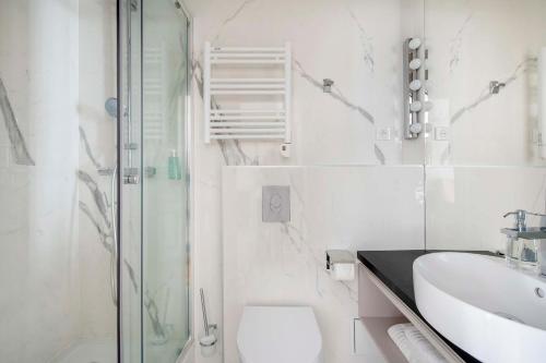 a bathroom with a toilet and a sink and a shower at LE BEAU MARAIS - Luxury Apartments, AIR COND, LIFT in Paris