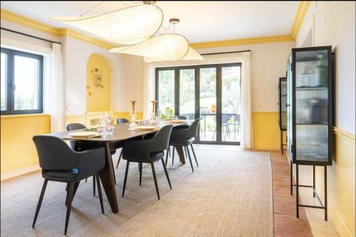 a dining room with a table and chairs at Colorful Villa with pool by OTYNA AM in Estoril