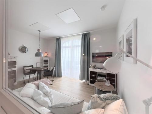 a white living room with a couch and a table at Haus Alexandra - Ferienwohnung Dat Büdche in Wangerooge