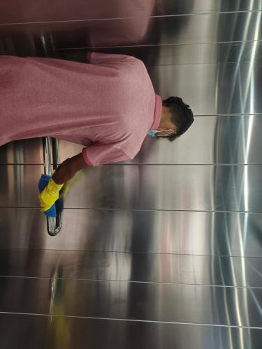a man in a pink shirt leaning against a wall at AGS Residency in Ernakulam