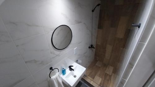 a white bathroom with a sink and a mirror at Adrogue Apart Airport Shuttle 24hs in Burzaco