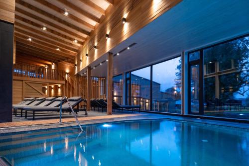 una piscina cubierta en una casa con ventanas en Futangue Hotel & Spa, en Lago Ranco