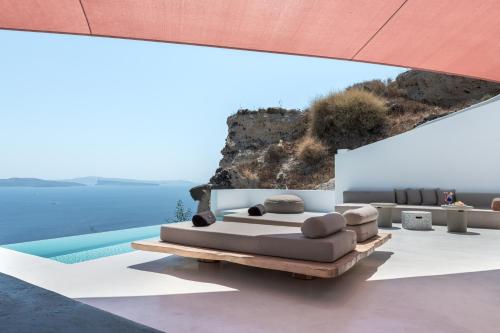 a room with a bed and a pool at Andronis Luxury Suites in Oia