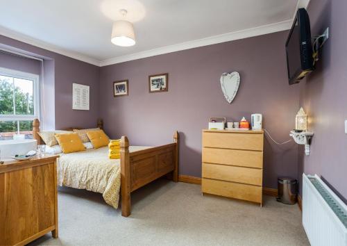 a bedroom with a bed and a dresser and a tv at Cross Villa Accommodation in Templeton