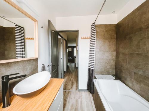 uma casa de banho com uma banheira branca e um lavatório. em Appartement meublé 60m2 Le Drômardèchois ARDÈCHE -GESTLOC- em Tournon-sur-Rhône