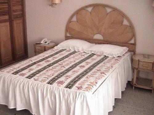- une chambre avec un grand lit et une tête de lit en bois dans l'établissement Hotel Don Jorge c.a, à San Antonio del Táchira