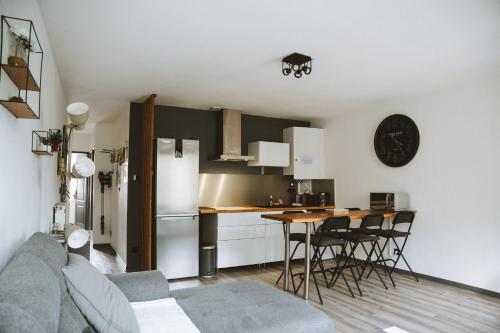 a kitchen with a refrigerator and a table and chairs at Le DrômArdèchois - Gîte meublé 6 personnes Tournon sur Rhône - ÉCOLODGÎTE in Tournon-sur-Rhône