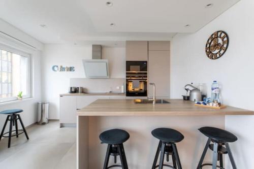 a kitchen with two bar stools and a counter top at Wonderful Two Bedroom Apartment at Limpertsberg with Parking, near Tram in Luxembourg