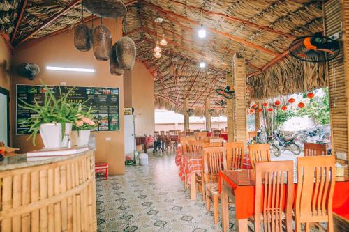 een restaurant met houten tafels en stoelen en een bar bij Tam Coc Sky Bungalow in Ninh Binh