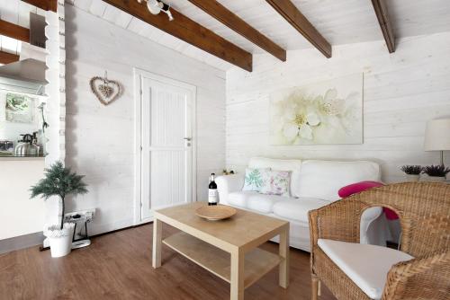 a living room with a white couch and a table at Cottage Hibiscus among Avocados in La Orotava