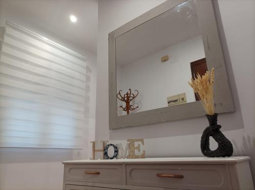 a mirror on a wall above a dresser in a room at Balcón del Cardenal in Baeza
