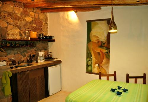 una cocina con una mesa y una pintura en la pared en Cabañas Azul Andino en Purmamarca