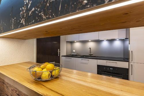 a kitchen with a bowl of fruit on a counter at Hotel Hemizeus & Iremia Spa in Zermatt