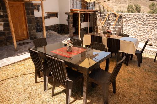 a dining table and chairs on a patio at Lodge El Portal de Qopuy in Coporaque