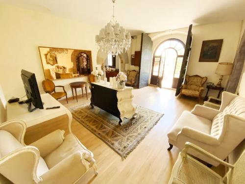 a living room with white furniture and a chandelier at Masia del siglo XIV cerca de Barcelona in Alella