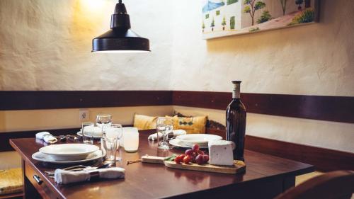 a table with plates and a bottle of wine on it at Casa Margarita 4 in Mala