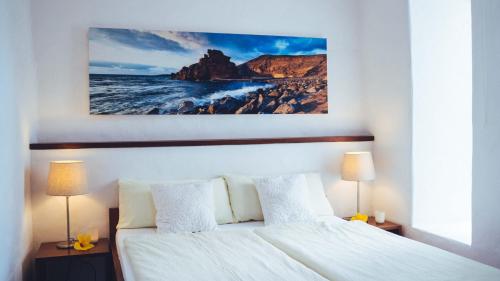 Un dormitorio con una cama y un cuadro en la pared. en Casa Margarita 2, en Mala