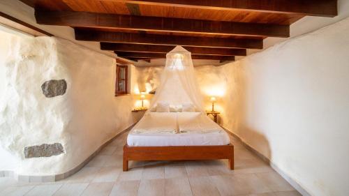 Un dormitorio con una cama en una habitación con techo. en Casa Margarita 3, en Mala