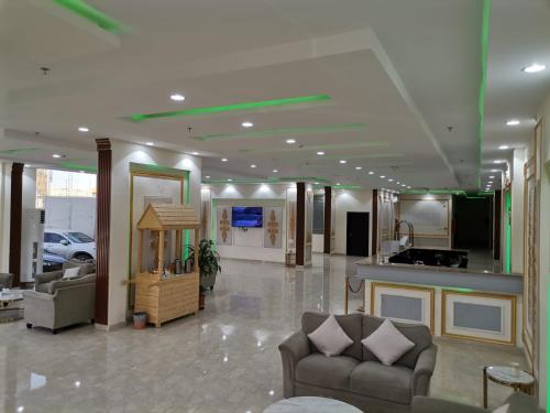 a living room with two couches and a kitchen at هزار الجوف للشقق المخدومة in Al Fayşalīyah