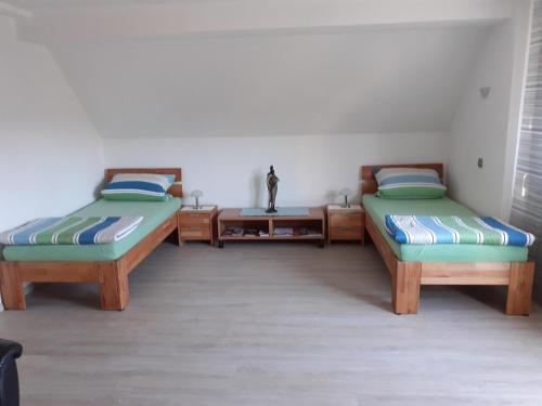 Habitación con 2 camas y mesa. en Ferienwohnung am Schloss mit Fitnessraum, en Kürmreuth