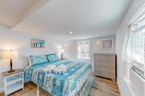 a bedroom with a bed and a dresser and a window at Gateway to Cape Cod in West Yarmouth