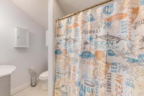 a bathroom with a shower curtain with drawings on it at Gateway to Cape Cod in West Yarmouth