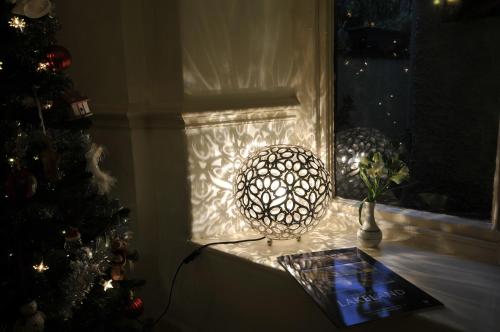 a window with a christmas tree and a vase with a flower at St John's Lodge incl off-site leisure club in Windermere