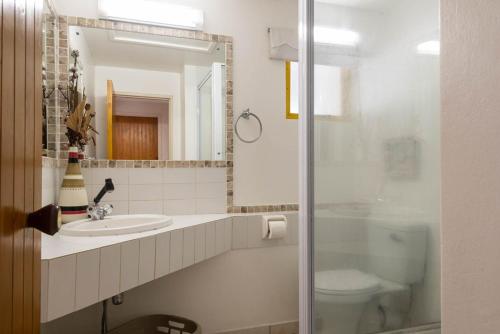 uma casa de banho com um lavatório, um WC e um espelho. em 65 Perissa em Ballito