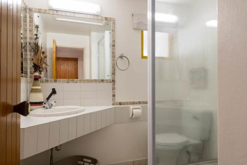 a bathroom with a sink and a toilet and a mirror at 65 Perissa in Ballito