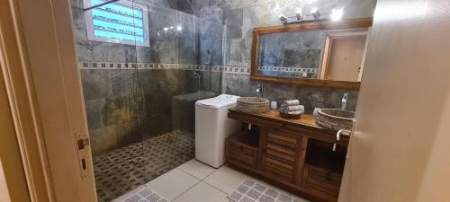 a bathroom with a shower and a toilet and a sink at Villa Mahavel in Saint-Pierre