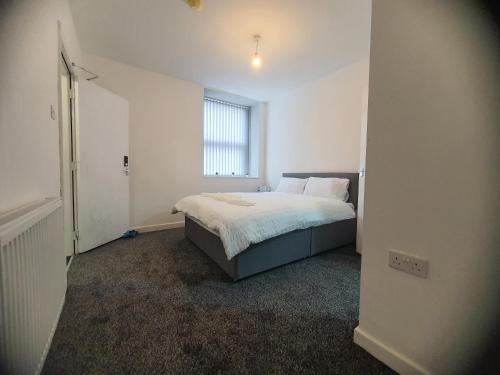 a bedroom with a bed and a window at Blackwood Residence in Accrington
