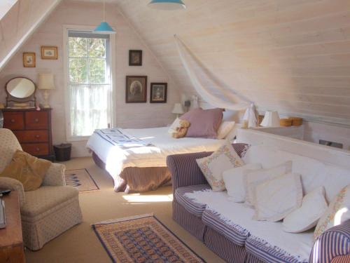 a bedroom with a bed and a couch in a room at Devon Cottage in Bowral