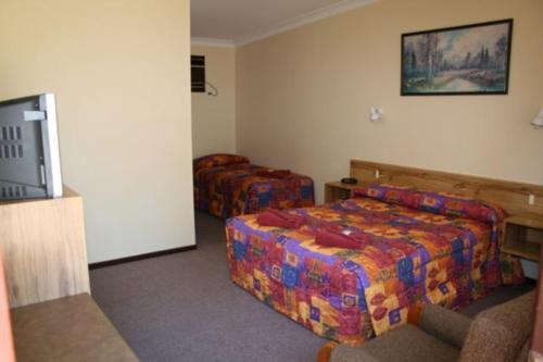 Un pat sau paturi într-o cameră la Wagon Wheel Motel & Units