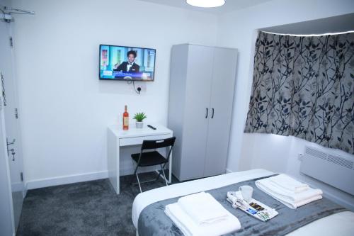 a hotel room with a bed and a desk with a mirror at Stunning 2-Bed Apartment in Harrow in Harrow