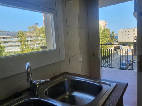 a kitchen sink with a view of a balcony at Payet Apartments in L'Estartit
