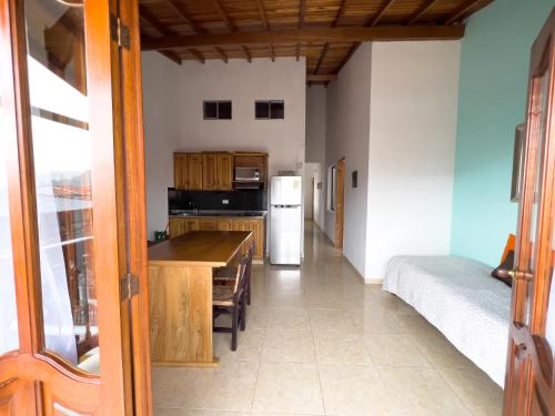 a kitchen with a table and a refrigerator at Apartamentos Primavera in Jardin