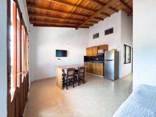 a kitchen with a table and a refrigerator at Apartamentos Primavera in Jardin