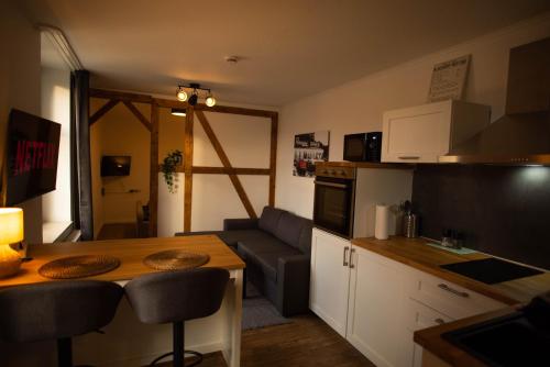 a kitchen and living room with a table and a couch at Residenz am Kurpark - Ferienwohnungen in zentraler Lage I Privatparkplatz in Bad Rothenfelde
