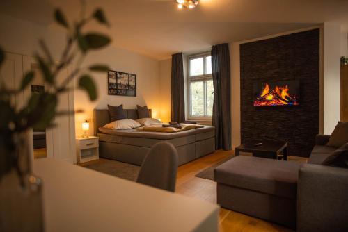 ein Wohnzimmer mit einem Bett und einem Kamin in der Unterkunft Residenz am Kurpark - Ferienwohnungen in zentraler Lage I Privatparkplatz in Bad Rothenfelde