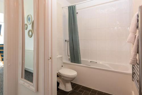 a bathroom with a toilet and a bath tub at Room 3 - Glan Neigr in Rhosneigr