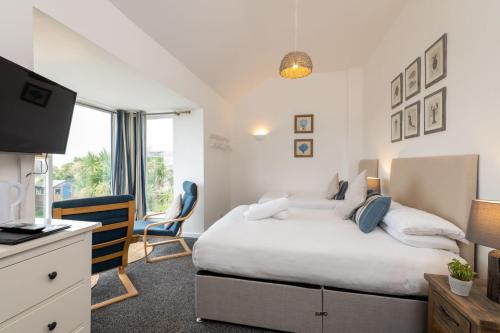 a bedroom with a bed and a desk and a television at Room 3 - Glan Neigr in Rhosneigr