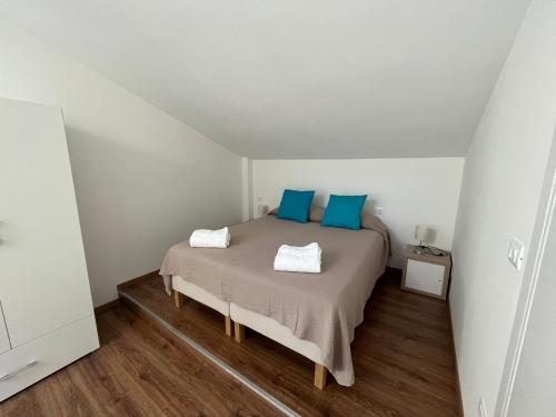 sypialnia z łóżkiem z niebieskimi poduszkami w obiekcie Guest House All'83 w mieście Grosseto