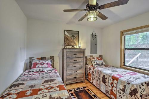 een slaapkamer met twee bedden en een plafondventilator bij Cozy Murphy Cabin Retreat with Deck and Fire Pit! in Salem