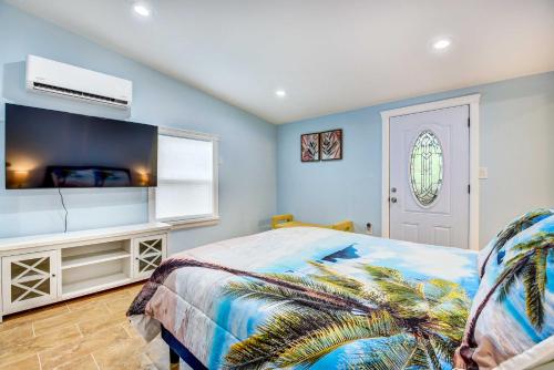 薩拉索塔的住宿－Sarasota Home with Screened Porch, Walk To Zoo!，一间卧室配有一张床和壁挂式电视