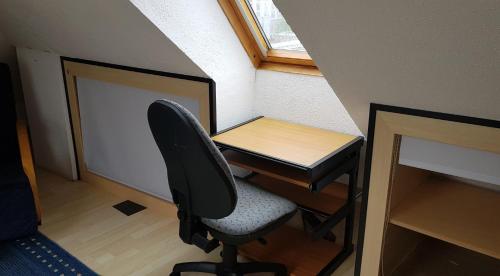 un ufficio con scrivania e sedia in una stanza di Zentral u gemütlich über den Dächern von Braunschweig a Braunschweig